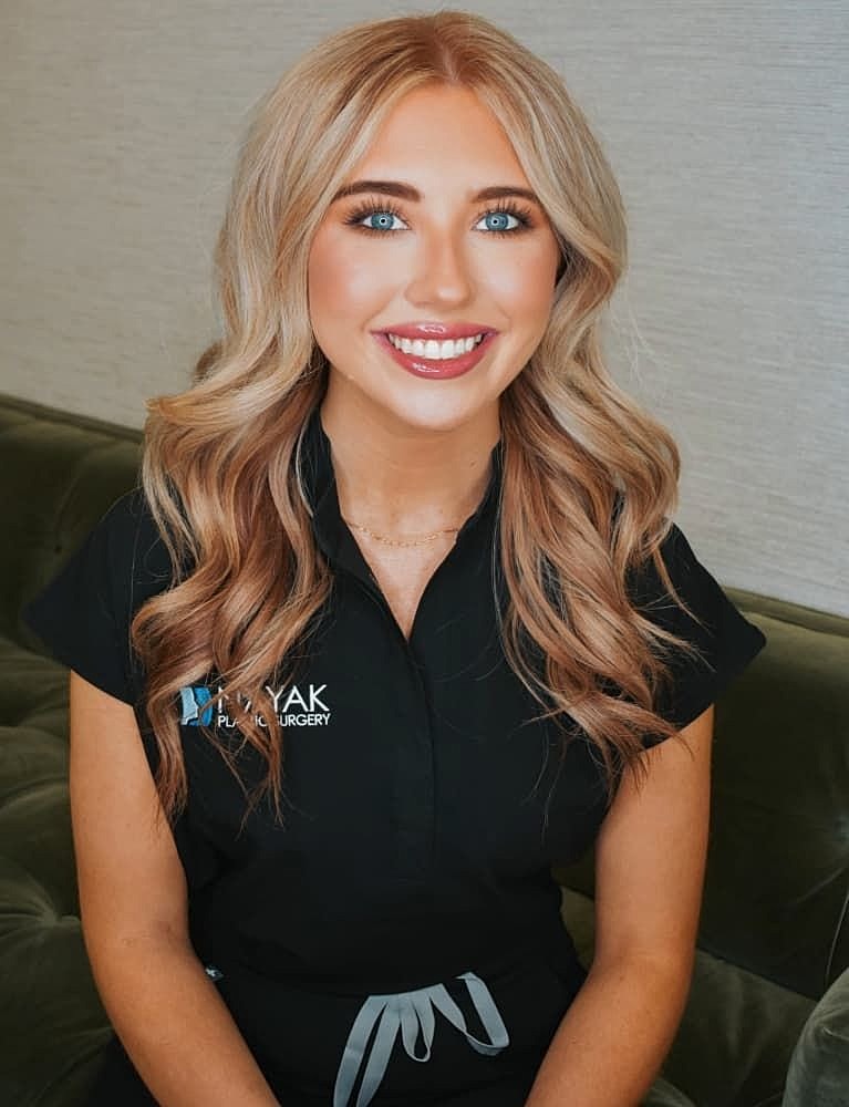 Smiling woman in black uniform, professional setting.