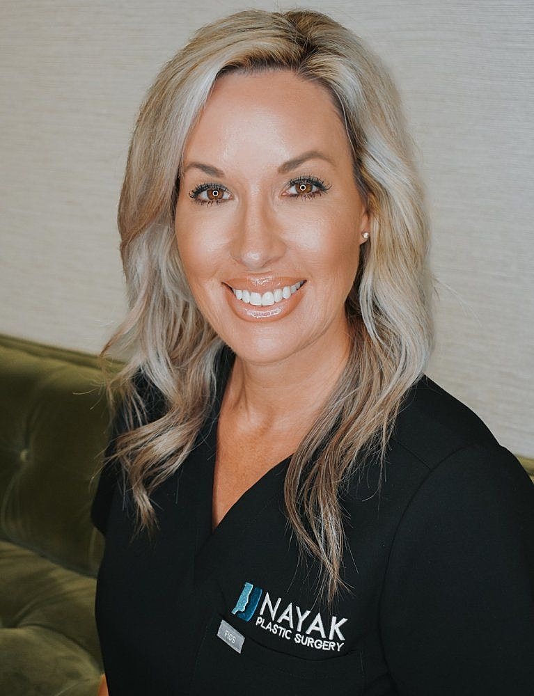 Female professional smiling in clinic uniform.