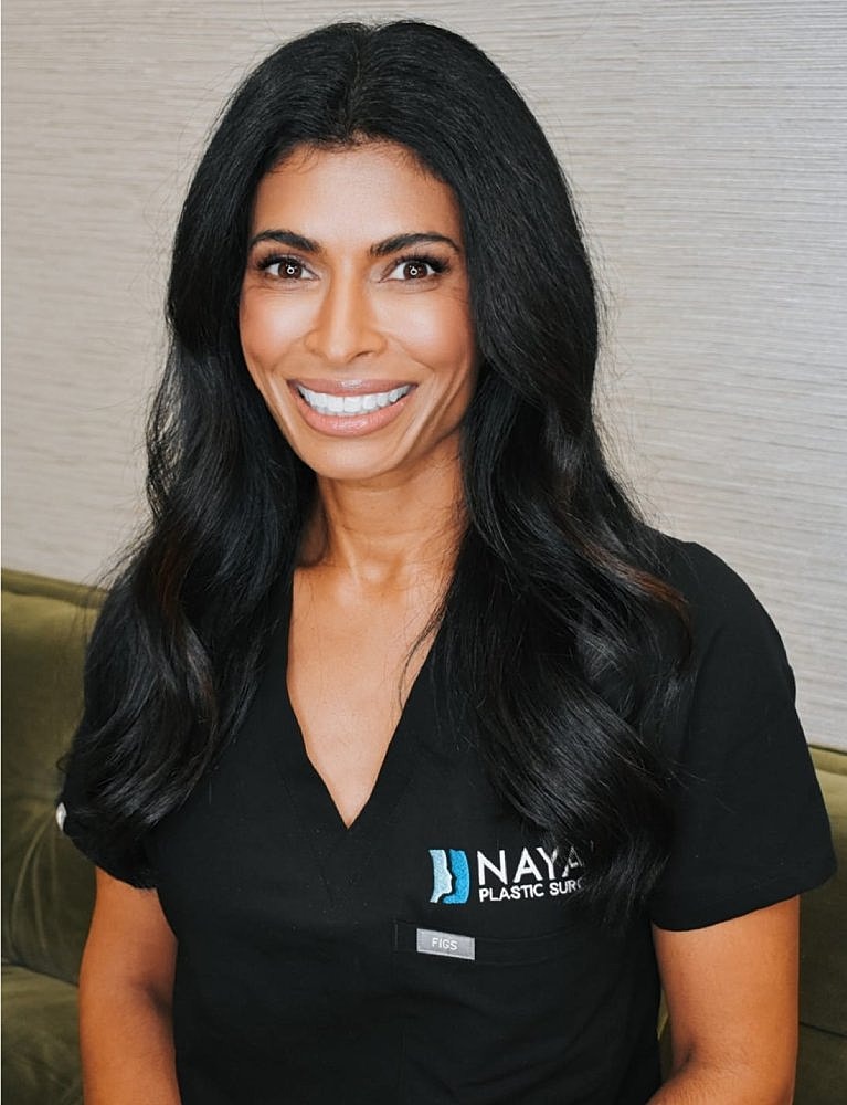 Smiling woman in black medical scrubs portrait.