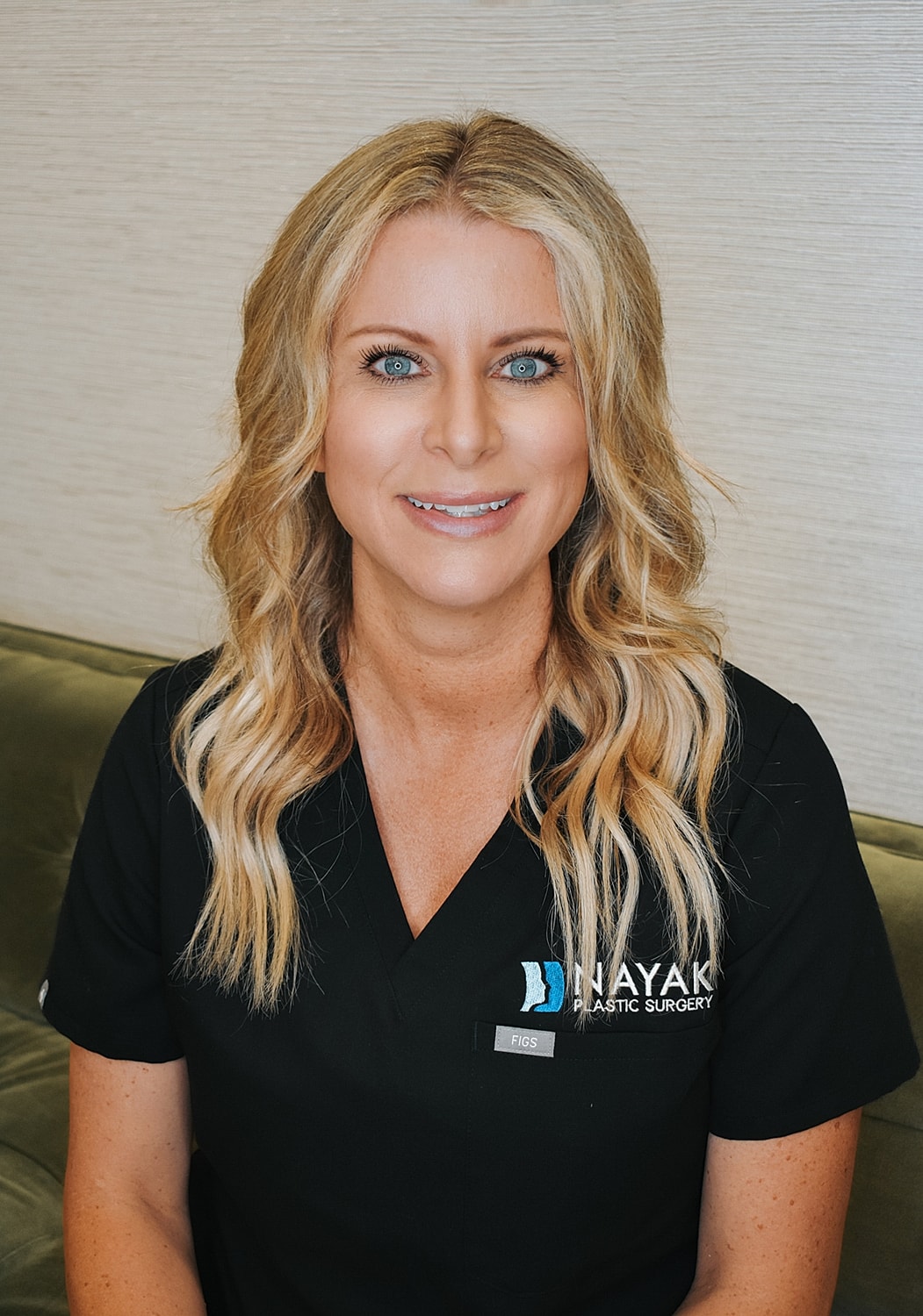 Female medical professional smiling in professional attire.