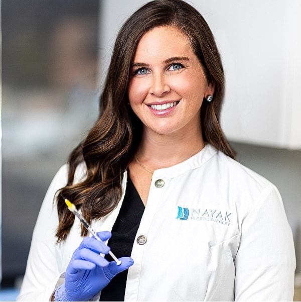 Smiling healthcare professional holding a syringe.