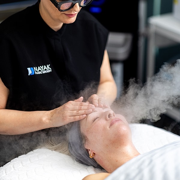 Facial treatment with steam in skincare clinic.