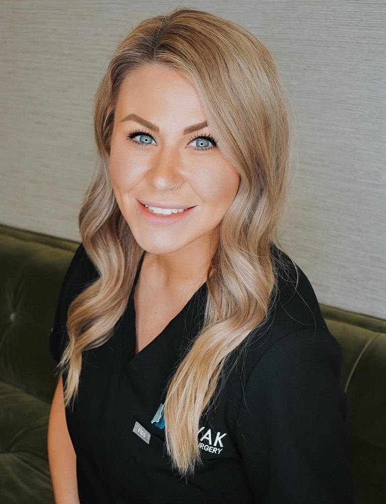 Smiling woman in medical uniform, professional setting.