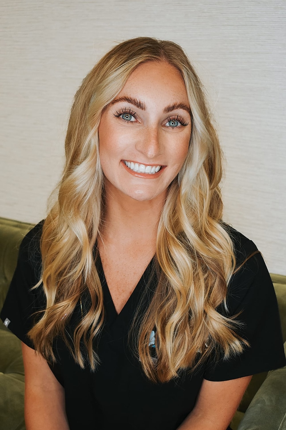 Smiling woman with long blonde hair in scrubs.