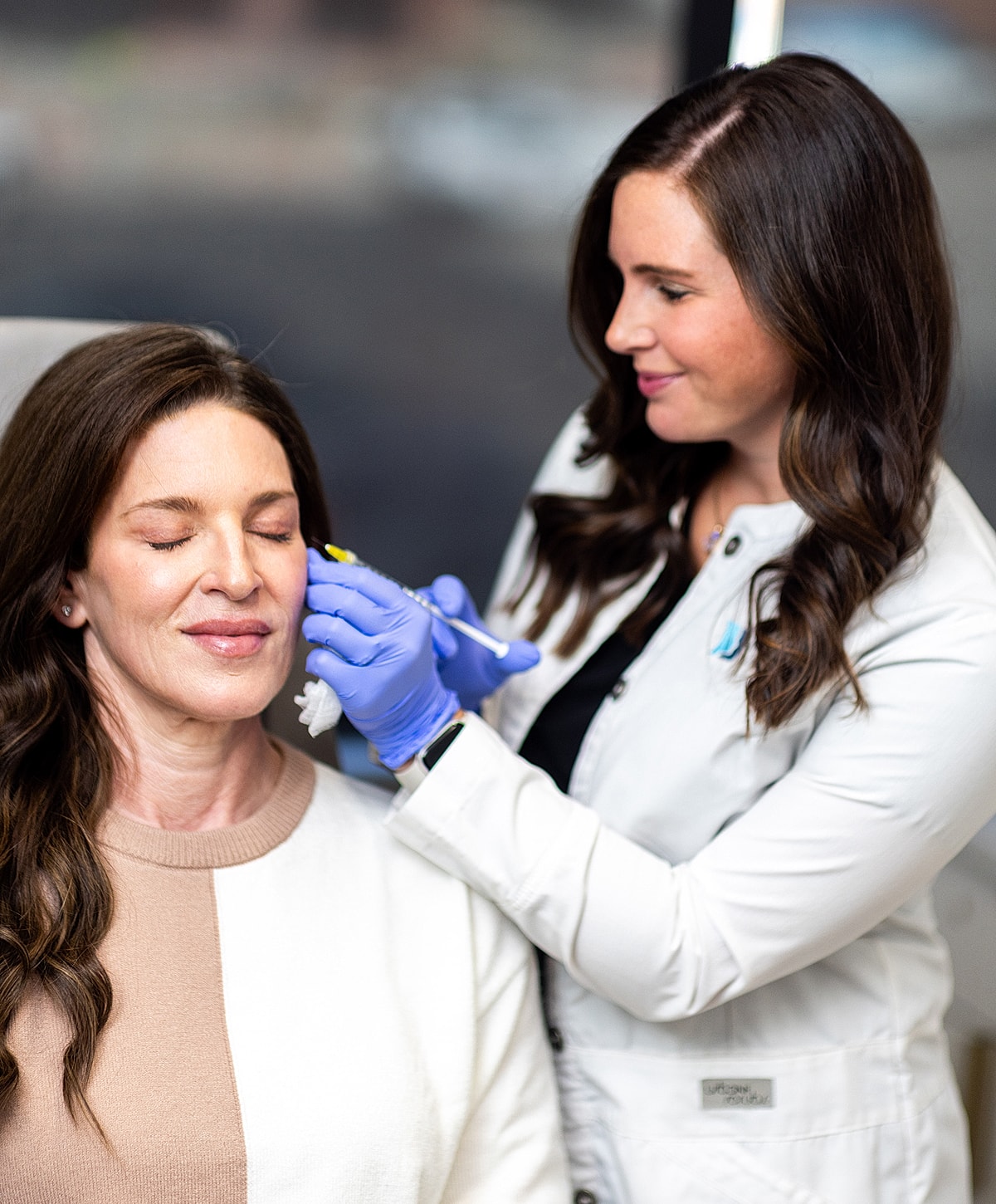 Woman receiving a cosmetic procedure from professional.