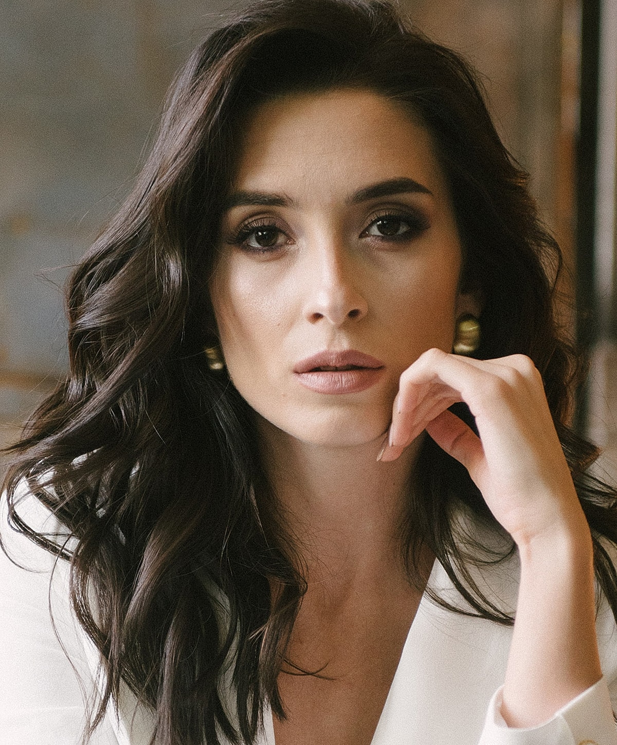 Woman with long dark hair and thoughtful expression.