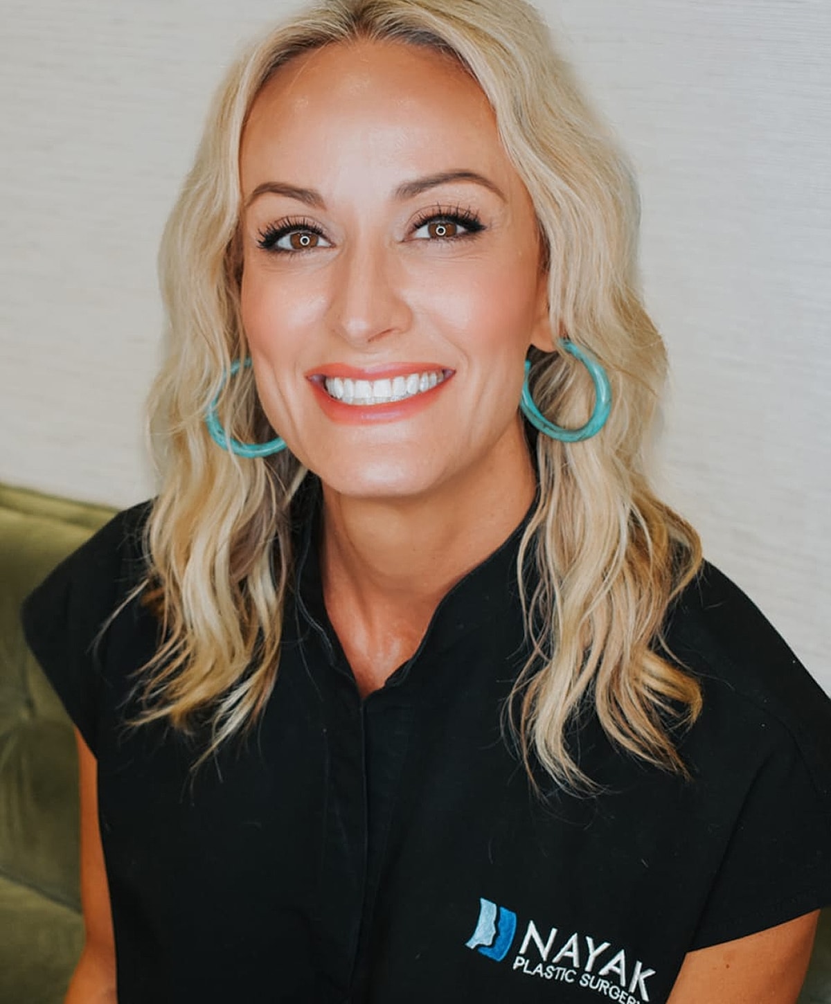 Smiling woman in professional attire, blonde hair.