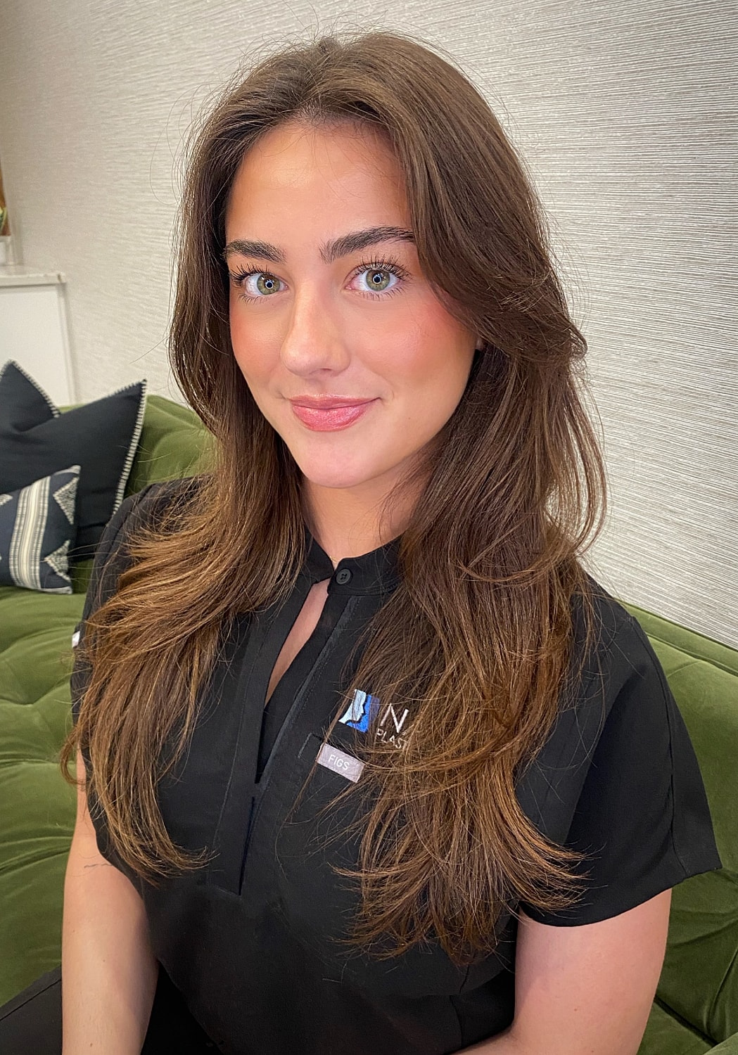 Woman with long hair smiling in professional attire.