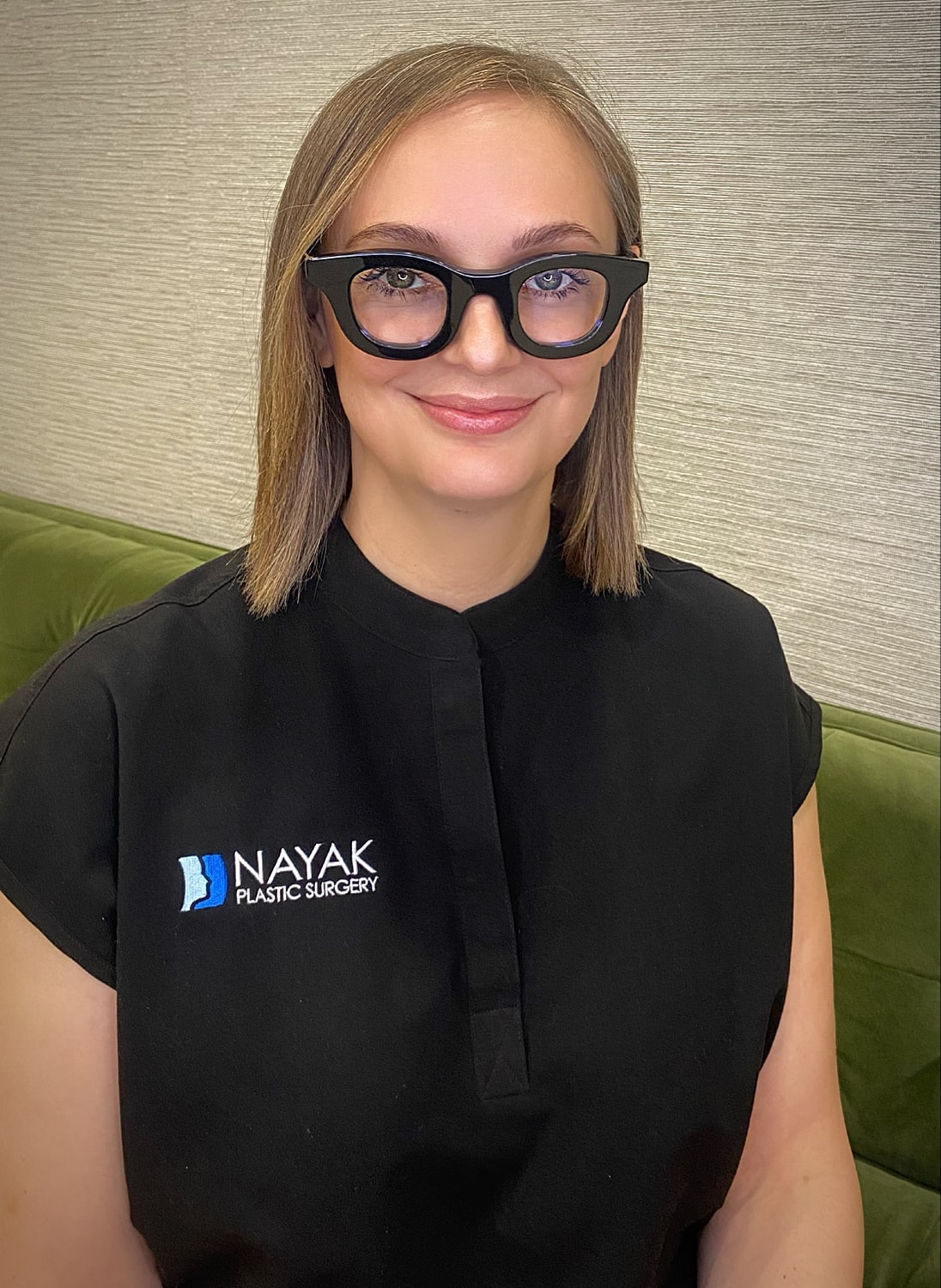 Woman in glasses at plastic surgery office.