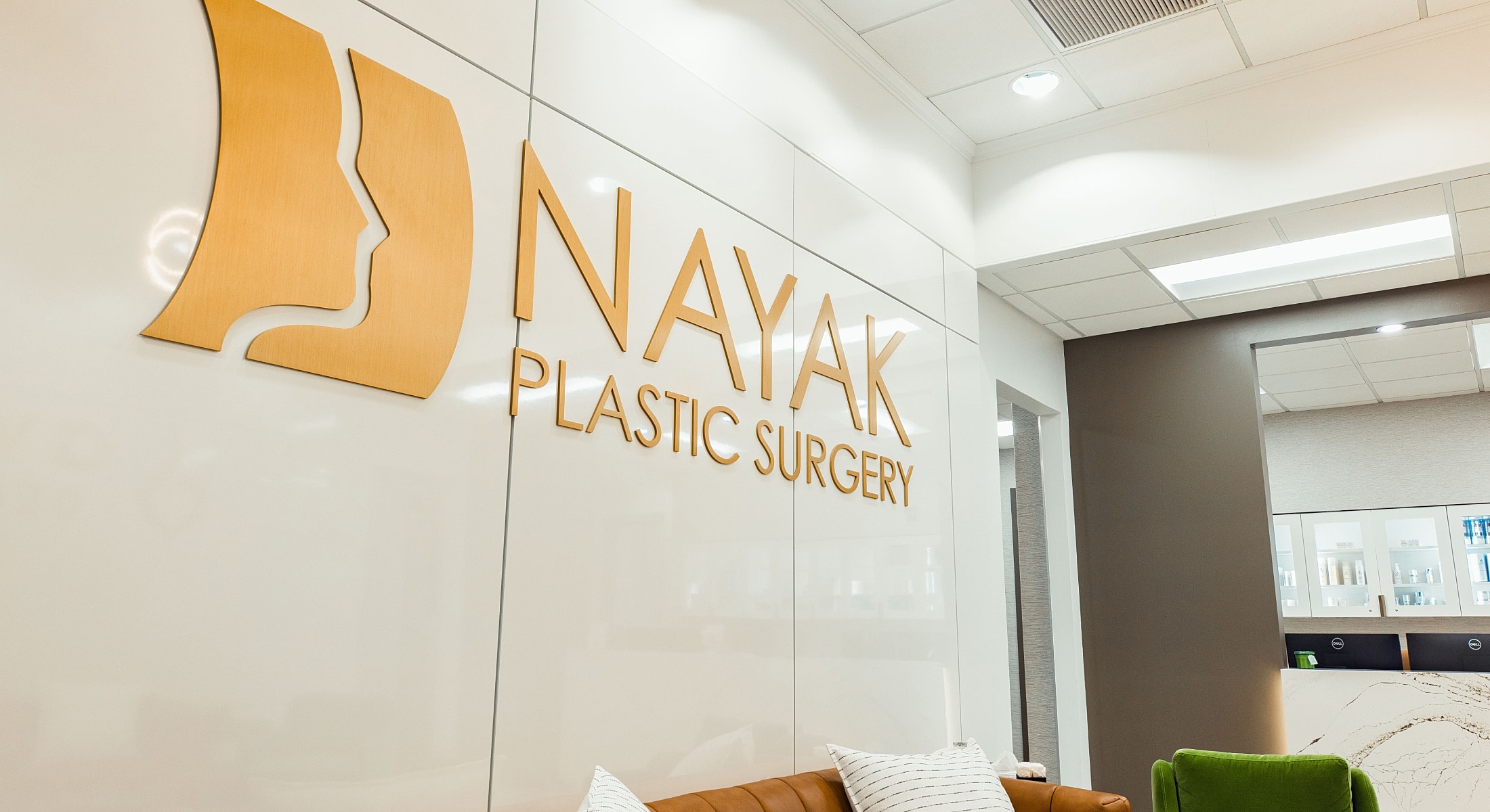 Nayak Plastic Surgery office interior and logo.