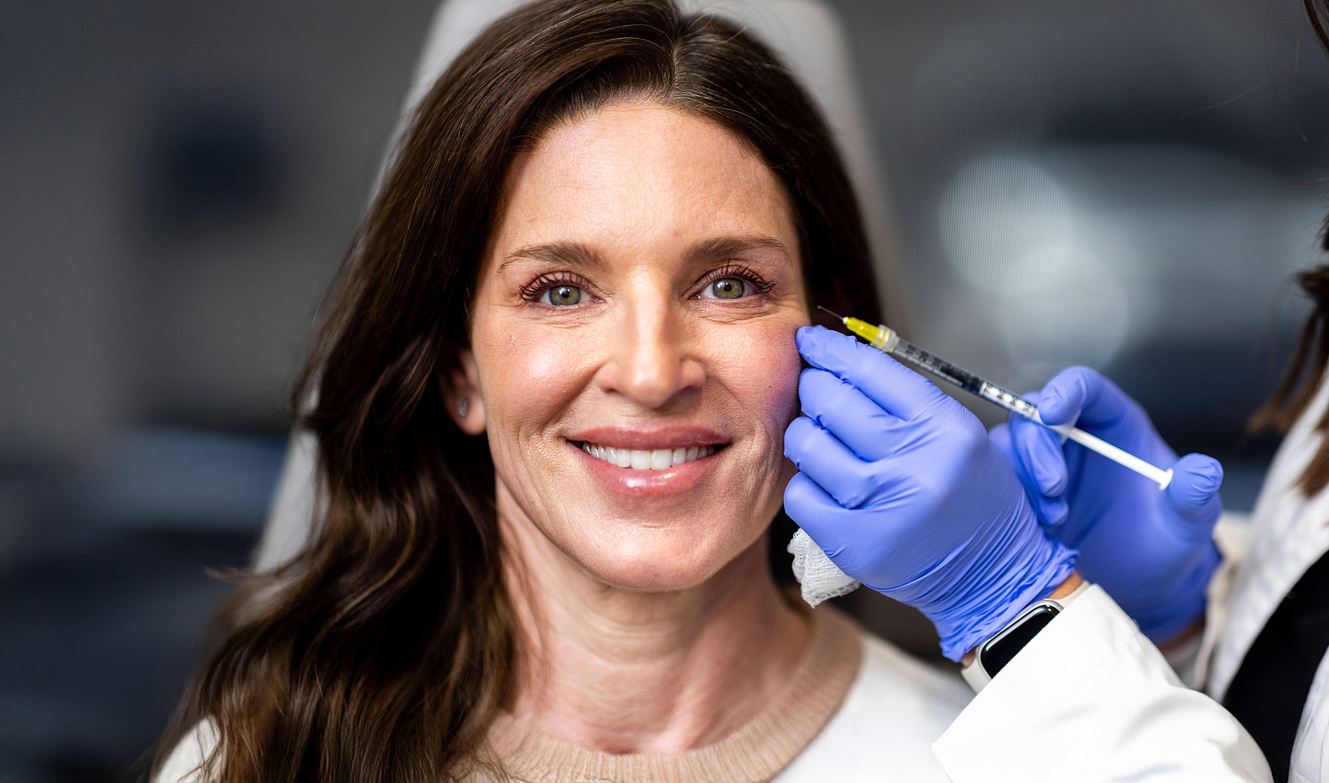 Woman receiving cosmetic injection at clinic.
