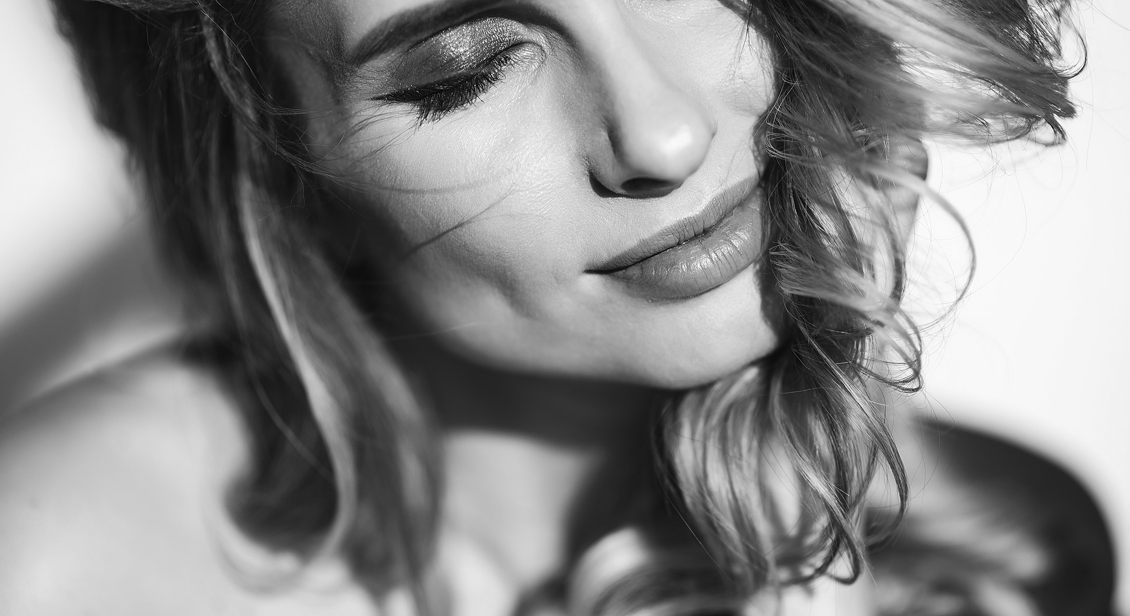 Close-up of woman with wavy hair and soft expression.